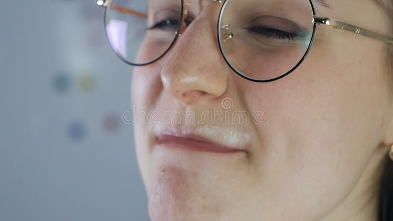 Lovely girl drinking fresh milk and getting milk moustache