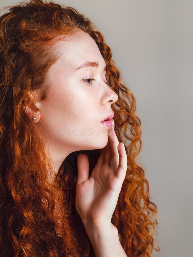 Lovely Girl with Long Red Curly Hair and Brown Eyes in Profile in the  Studio on a Gray Background Stock Photo - Image of artist, human: 179858840