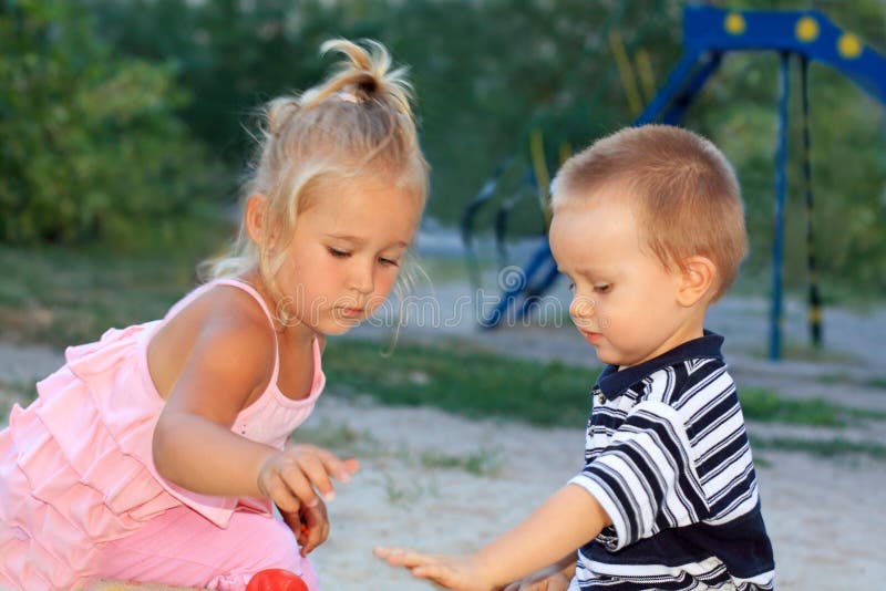 Lovely little children playing in the sandbox