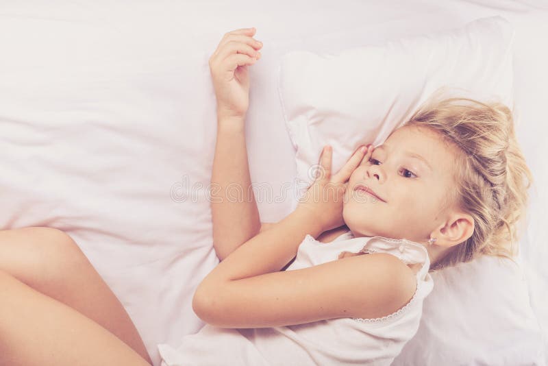 Lovely little girl sleeping on the bed