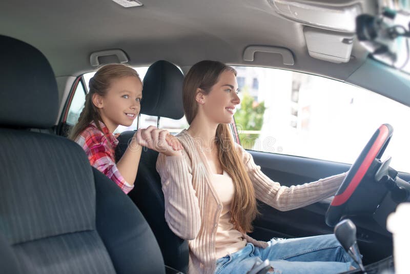 Happy Daughter Holding Her Mom`s Hand Driving The Car Stock Image