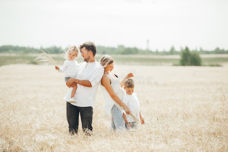 Lovely portrait of a young beautiful family in wheat field on warm and sunny summer day royalty free stock photos Lovely portrait of a young beautiful family in wheat field on warm and sunny summer day royalty free stock photos