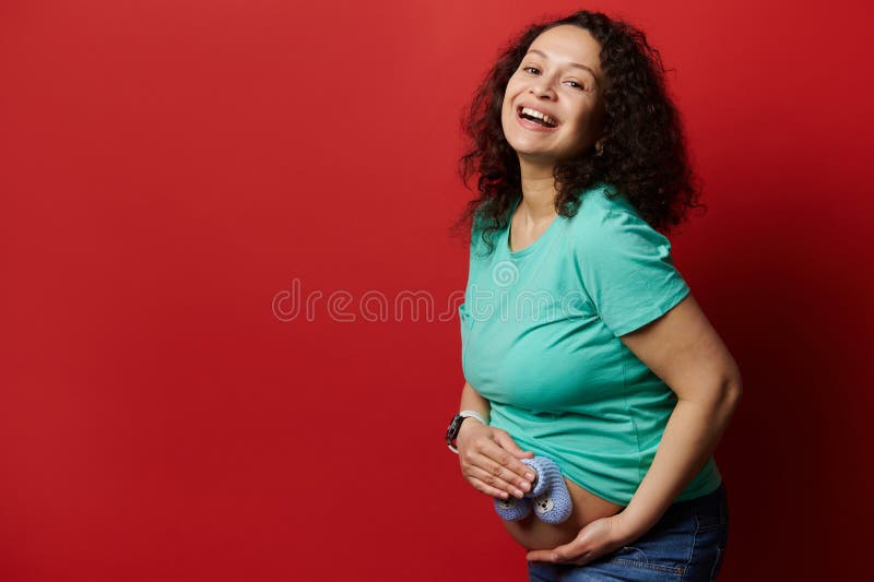 Beautiful Pregnant Woman Laughing Looking at Camera, Holding Baby