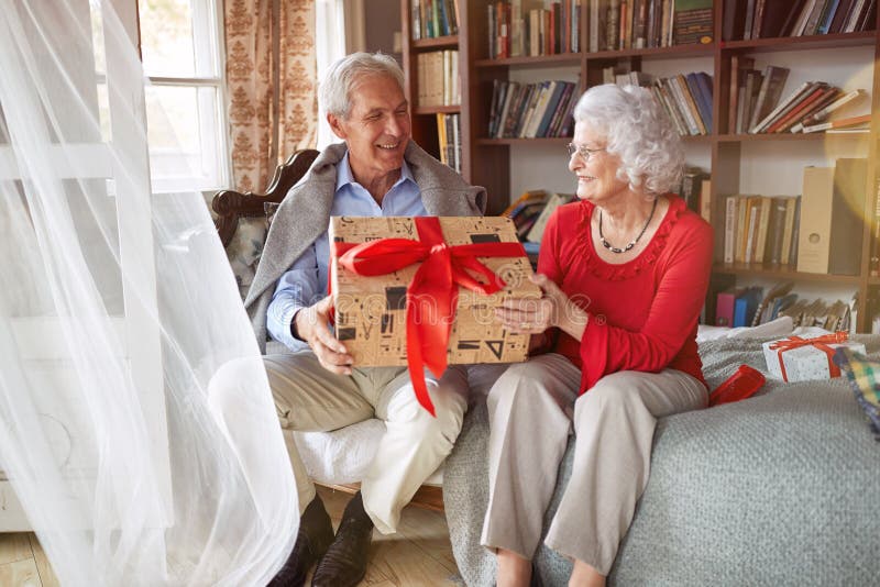 Lovely Senior Couple Exchanging Christmas Gifts stock images Lovely Senior Couple Exchanging Christmas Gifts stock images