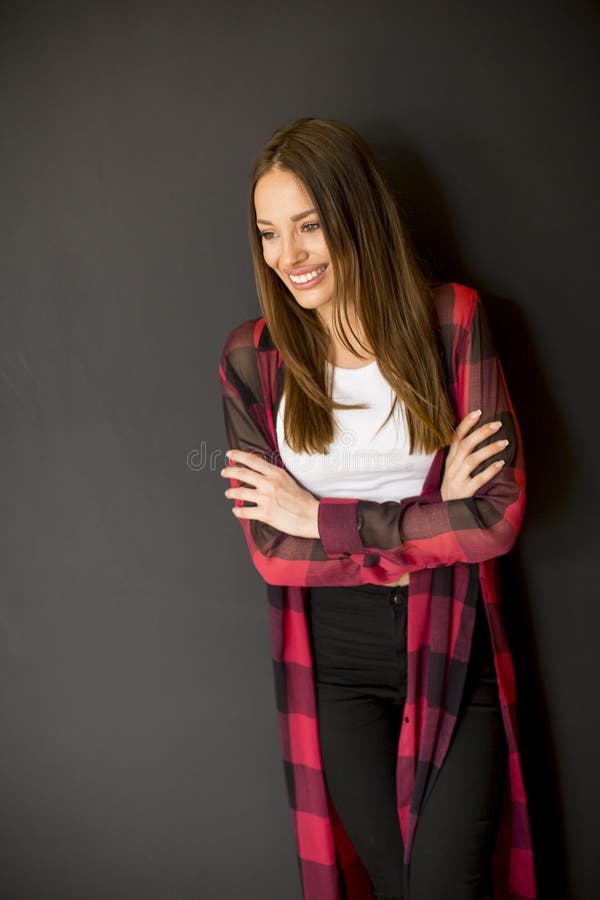Lovely smiling young long haired woman standing by the wall royalty free stock images Lovely smiling young long haired woman standing by the wall royalty free stock images