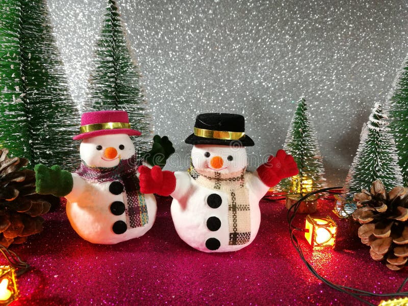 Lovely Snowman pink gliter background near ornament lighting bulb at silent night, holy night, Merry Christmas and hap