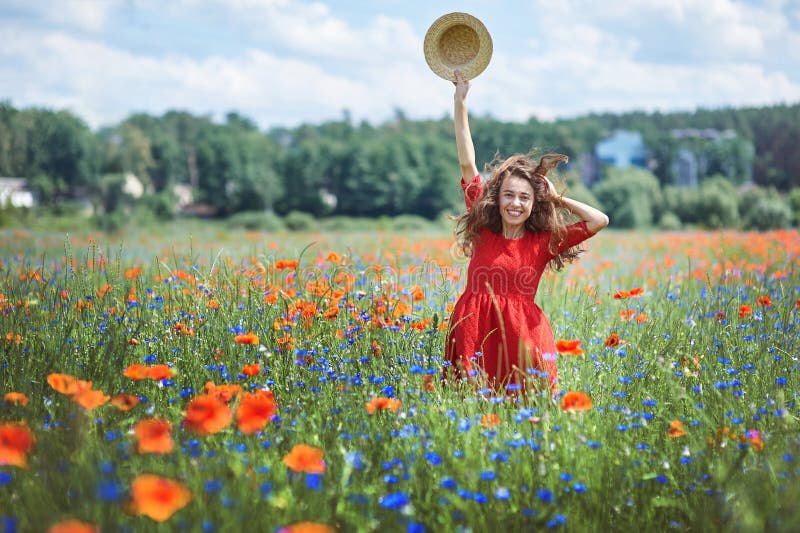 Lovely young romantic woman in straw hat on poppy flower field posing on background summer. Wearing straw hat. Soft. Colors royalty free stock photo Lovely young romantic woman in straw hat on poppy flower field posing on background summer. Wearing straw hat. Soft. Colors royalty free stock photo