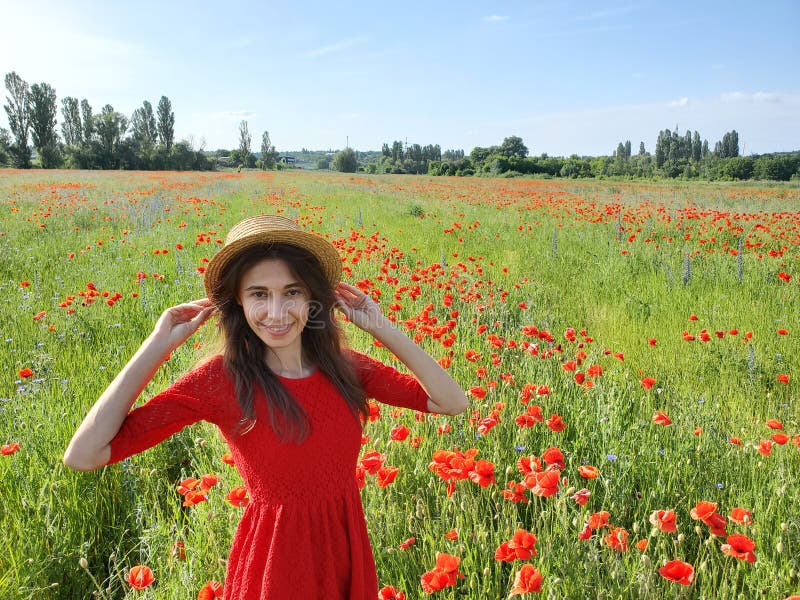 Lovely young romantic woman in straw hat on poppy flower field posing on background summer. Wearing straw hat. Soft. Colors royalty free stock photo Lovely young romantic woman in straw hat on poppy flower field posing on background summer. Wearing straw hat. Soft. Colors royalty free stock photo