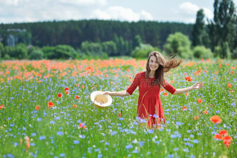 Lovely young romantic woman in straw hat on poppy flower field posing on background summer. Wearing straw hat. Soft. Colors stock image Lovely young romantic woman in straw hat on poppy flower field posing on background summer. Wearing straw hat. Soft. Colors stock image