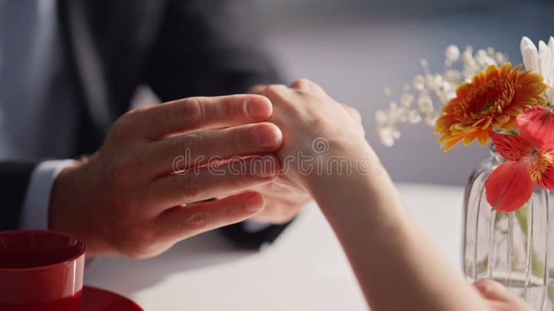 Lovers hands holding gently at cafe table closeup. Unknown romantic couple stock video footage