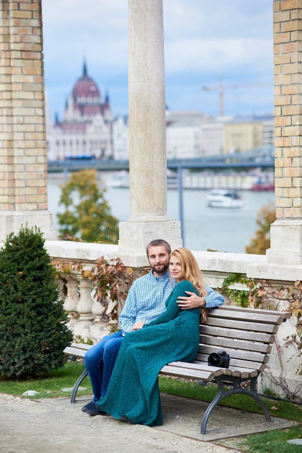 Lovers pair sits on bench near the columns of Budapest