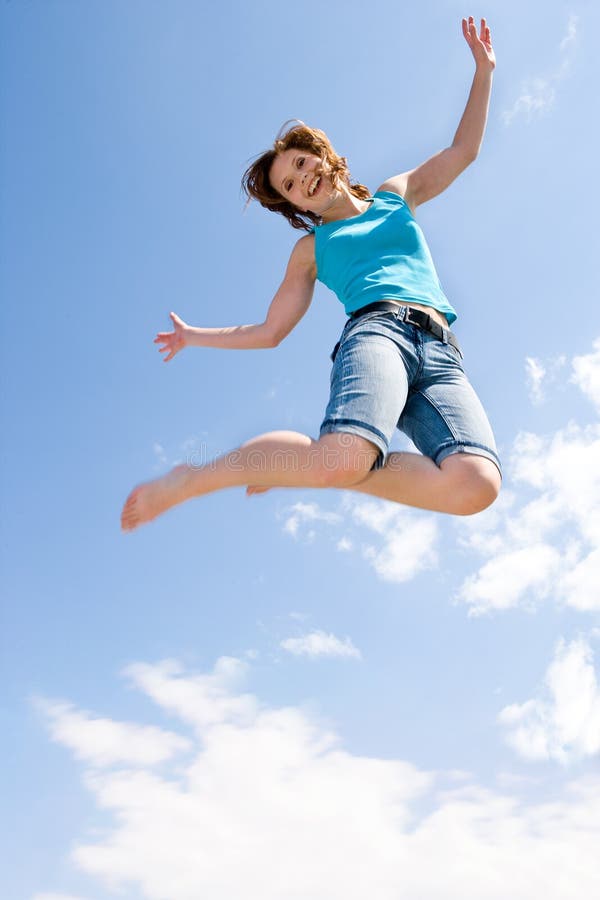 Junge, schöne Mädchen ist das springen unter dem Himmel.