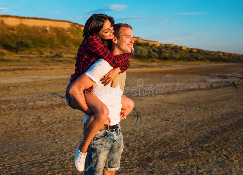 Lovestory пар на пляже на заходе солнца стоковое изображение Lovestory пар на пляже на заходе солнца стоковое изображение