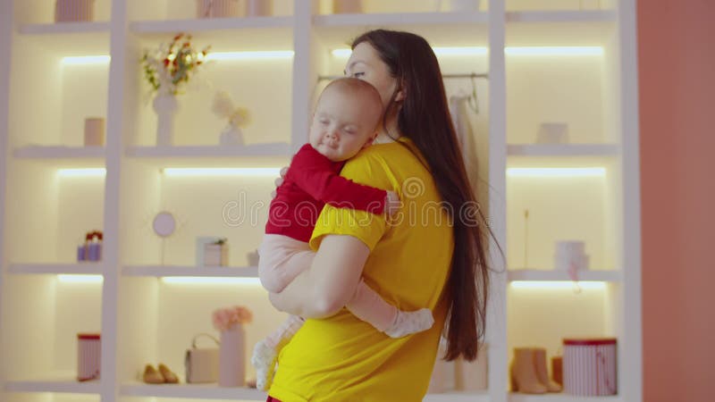 Loving caring charming mother holding curious adorable infant child at home