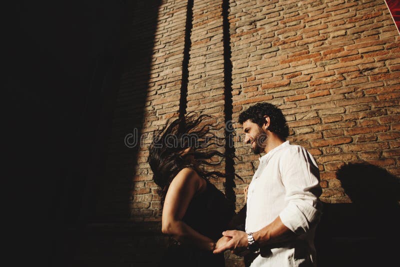 Loving couple enjoying a walk in the city. Behind them is the background is a red brick wall royalty free stock photos Loving couple enjoying a walk in the city. Behind them is the background is a red brick wall royalty free stock photos