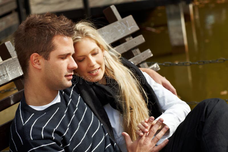 Loving couple resting on bench in park stock image