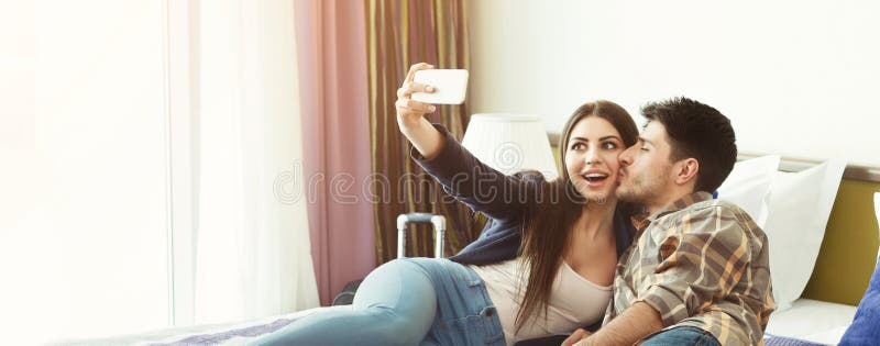 Loving Couple Resting In Hotel Room And Taking Selfie Stock Image