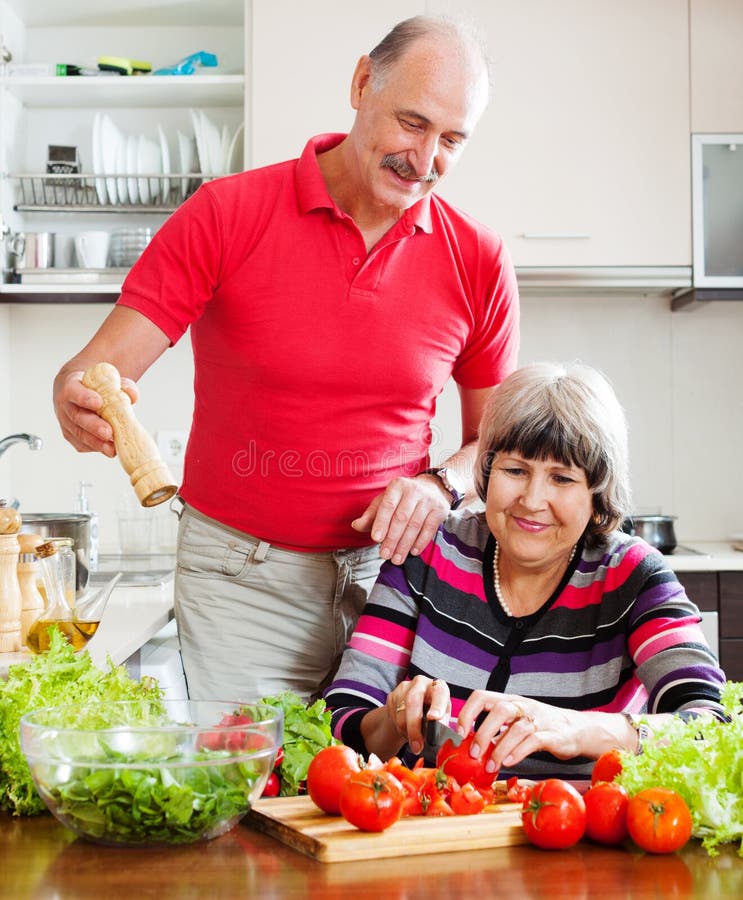 Loving elderly couple cooking with tomatoes royalty free stock image Loving elderly couple cooking with tomatoes royalty free stock image