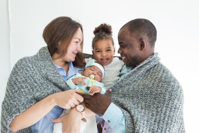 Loving father covers his family with a plaid. Happy multiethnic family. Family values