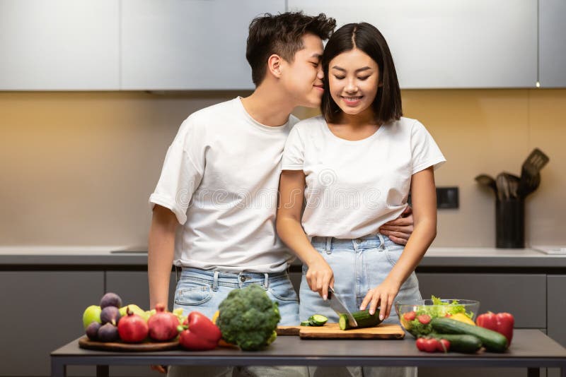 Loving Japanese Husband Kissing Wife Preparing Dinner Together In