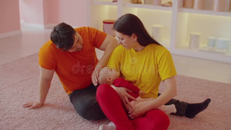Loving parents expressing love, care and tenderness while infant baby sleeping