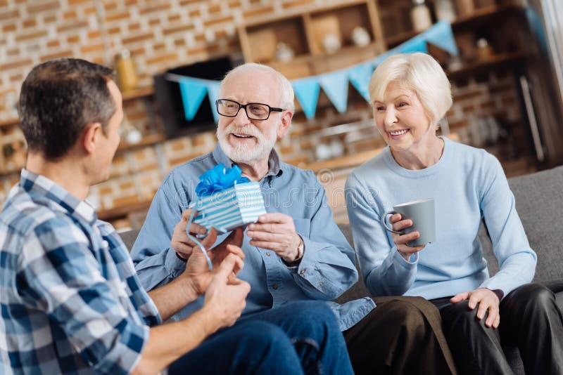 Loving Son Giving Birthday  Present To His Elderly  Father  