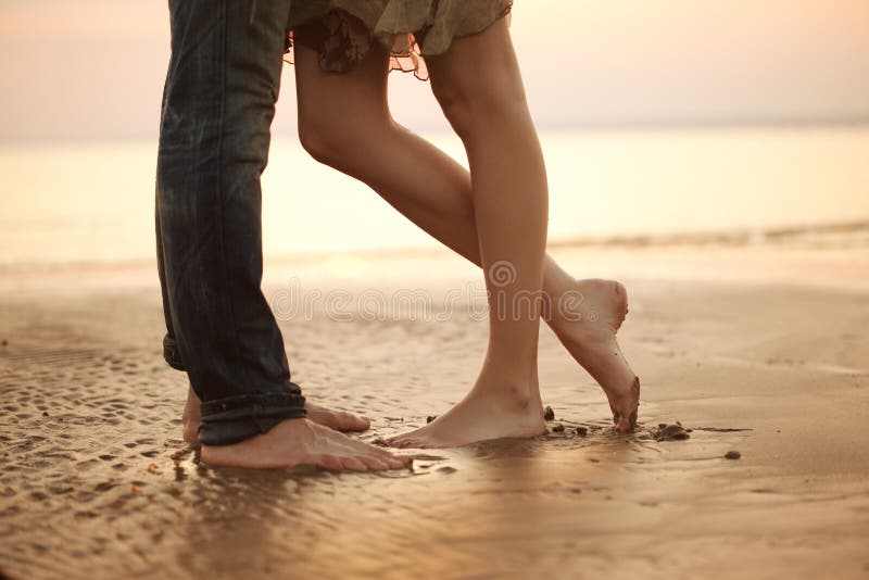 A loving young couple hugging and kissing on the beach. Lovers m