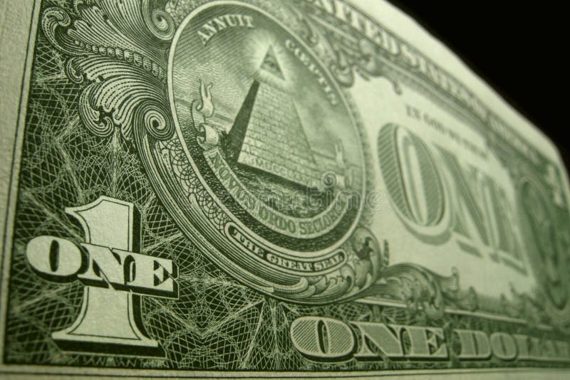 Low angle close up of the back of the US one dollar bill, focusing on ONE and 1 in the bottom left corner.