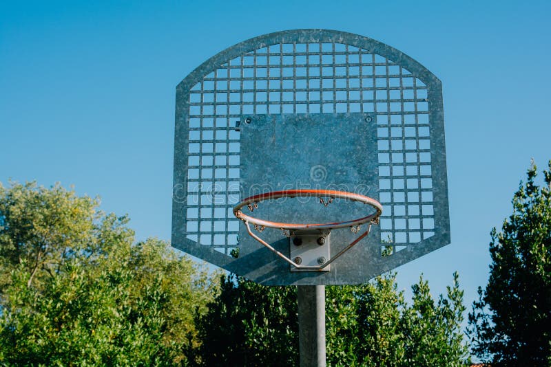 Low Angle Shot of a Basketball Hoop Under a Clear Blue Sky Stock Image