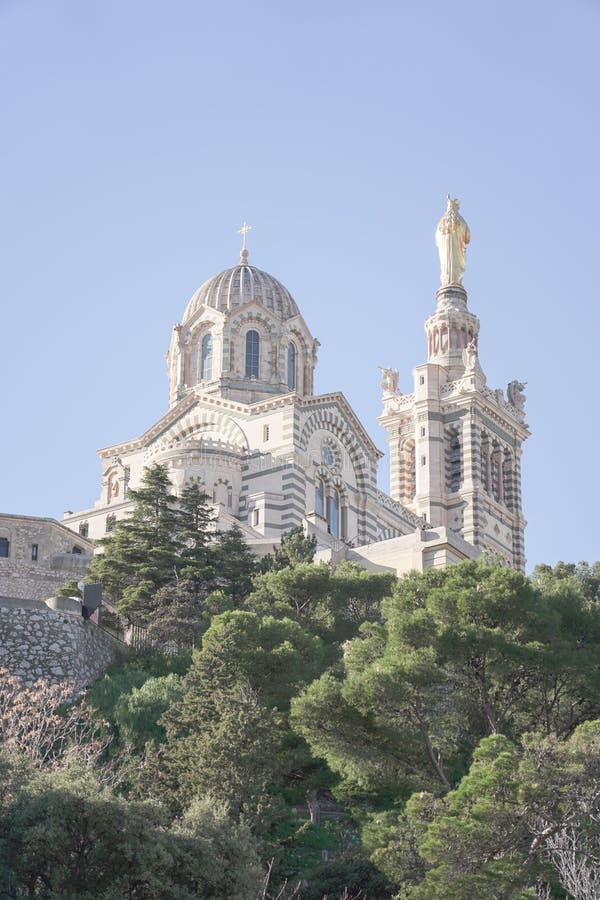 Low-angle shot the cathedral of Notre dame de lagarde in Marseille, France atop a rocky outcrop
