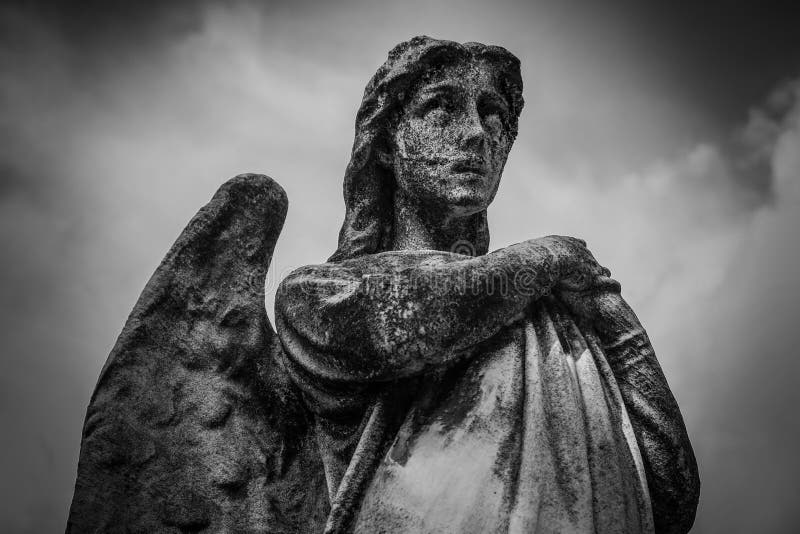 Low angle shot of a female statue with wings in black and white.