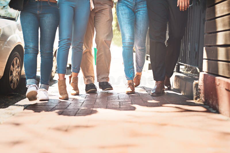 Lets take a stroll down the street guys. Low angle shot of a group of unrecognizable people walking together down a royalty free stock image