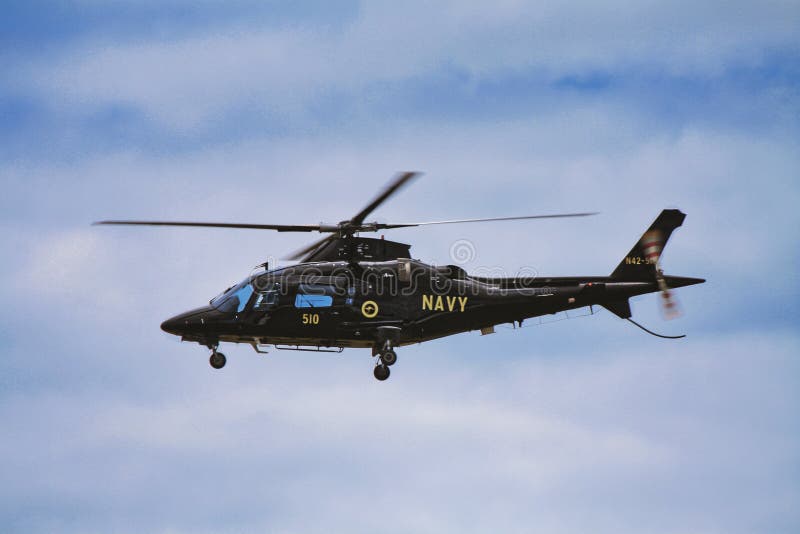 Low angle shot of a military helicopter with &x22;Navy&x22; text on board in flight in Australia