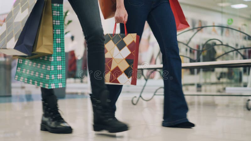 Low Angle Shot of Slim Girls Wearing Jeans Walking in Shopping Mall Together Carrying Colorful Paperbags after Day of Stock Video - Video of buying, holding: 133990859