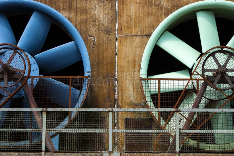 Low angle shot of two huge white and blue fans on a stone building stock image