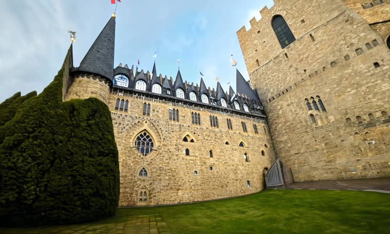 Low angle view of a large medieval castle with pointed towers and stone walls against a blue sky vector illustration