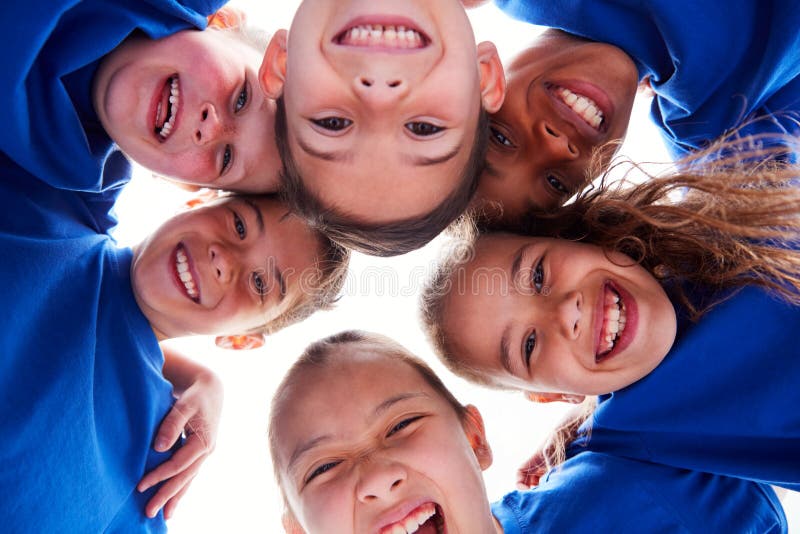 Low Angle View Looking Up Into Faces Of Children In Huddle On Sports Day royalty free stock image