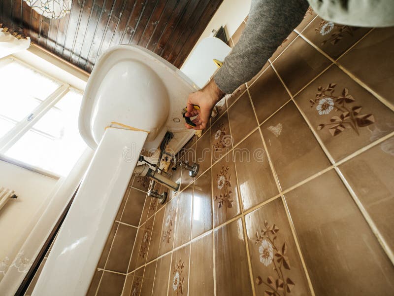 Manual Worker Removing the Old Sink in Vintage Old Bathroom Stock Photo