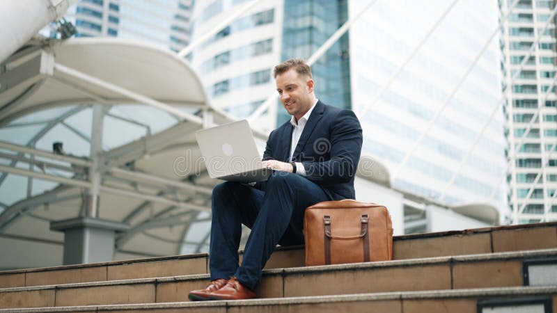 Low angle view of professional business man working on laptop at stairs. Urbane. stock photos