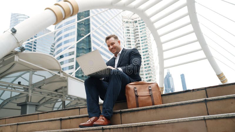 Low angle view of professional business man working on laptop at stairs. Urbane. stock photos