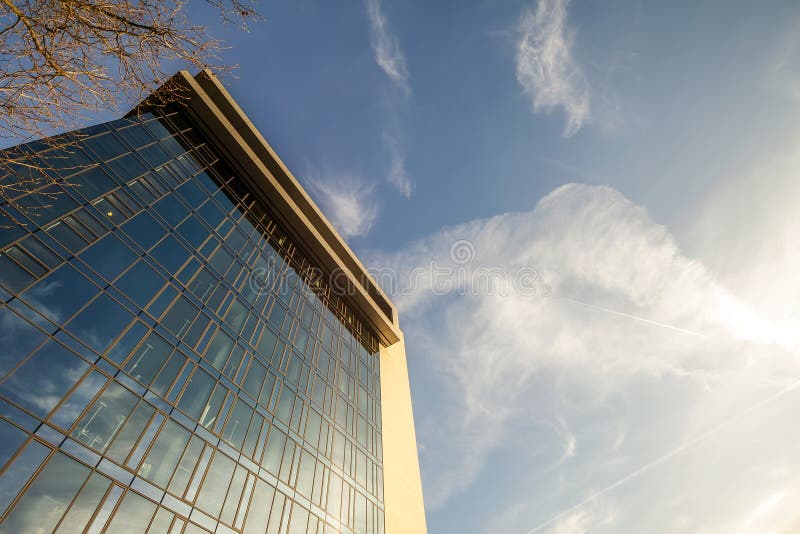 Low angle view of reflection of blue sky in glass wall of modern