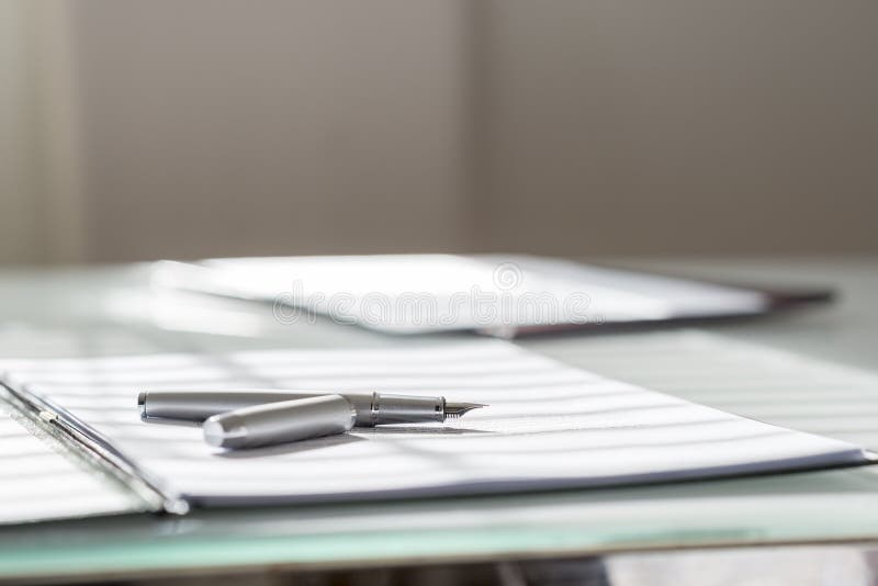 Low angle view of silver ink pen lying on white sheet of paper i royalty free stock photos Low angle view of silver ink pen lying on white sheet of paper i royalty free stock photos