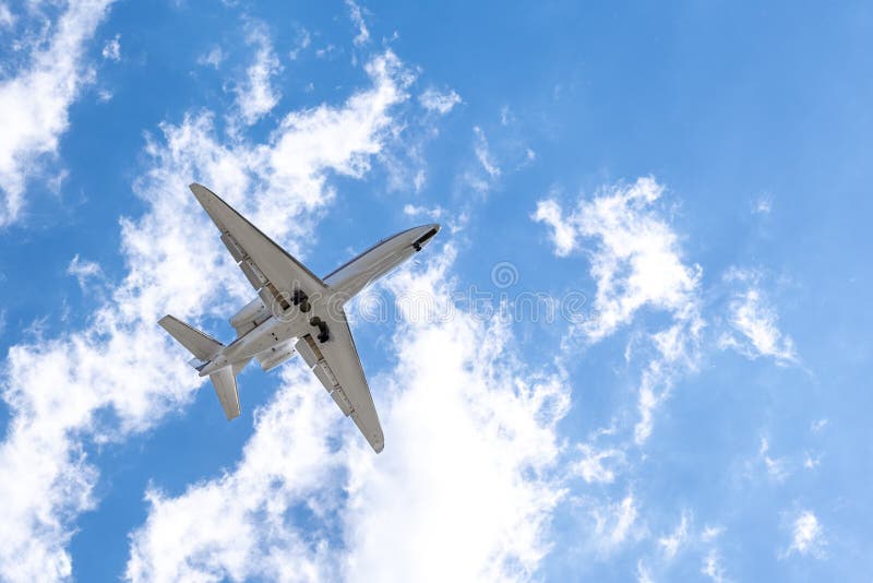 Airplane in the Sky on Background of Blue Sky and White Clouds Stock