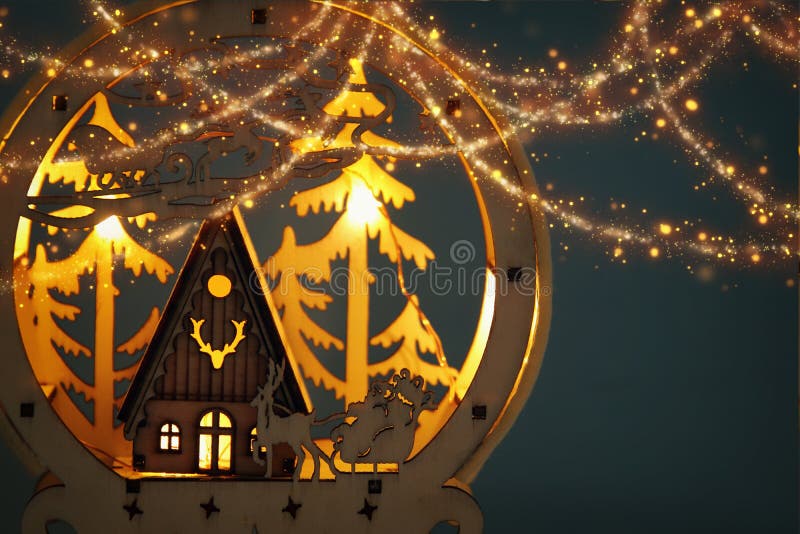 Low key Image of magical christmas scene of wooden pine forest, hut and santa claus over sleigh with deers. stock photos Low key Image of magical christmas scene of wooden pine forest, hut and santa claus over sleigh with deers. stock photos