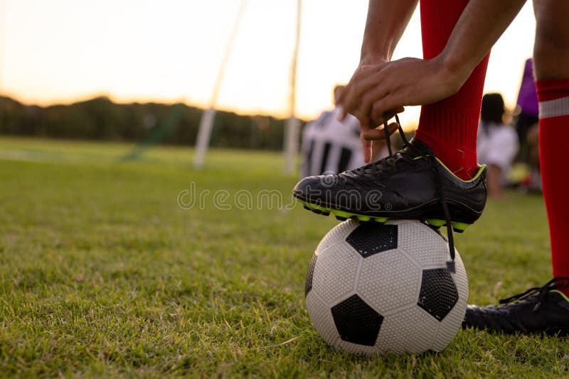 Faceless person standing with soccer ball between legs on grass · Free  Stock Photo