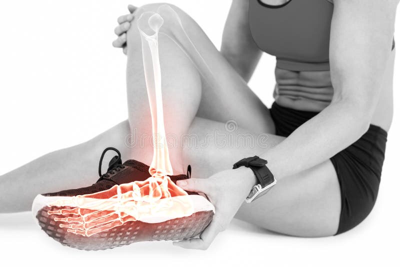 Low section of female athlete suffering from ankle pain on white background