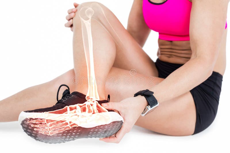 Low section of woman suffering from ankle pain on white background