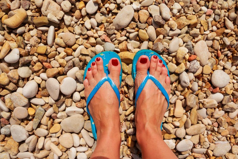 Foot rock. Beach Slippers in Leg. Slippers fir Rocky Beach. Woman on the Beach feet and Flip Flops. Beach Slippers pose image.