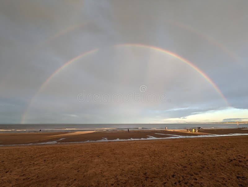Low Tide at Beach with Double Rainbow Stock Image Image of reflection
