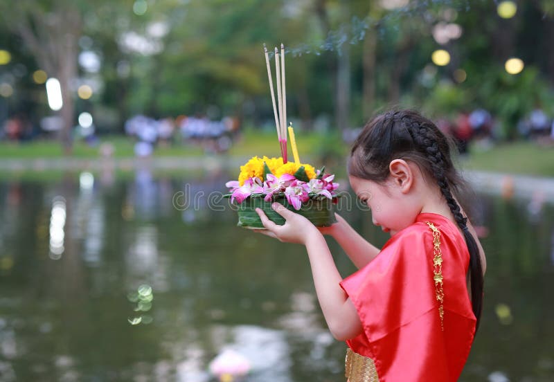 Loy Krathong festival, Asian Child girl in Thai traditional dress with holding krathong for forgiveness Goddess Ganges to